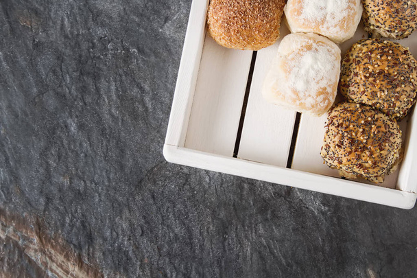 Fresh homemade bread from wheat. Dark background. A wooden tray. - Zdjęcie, obraz