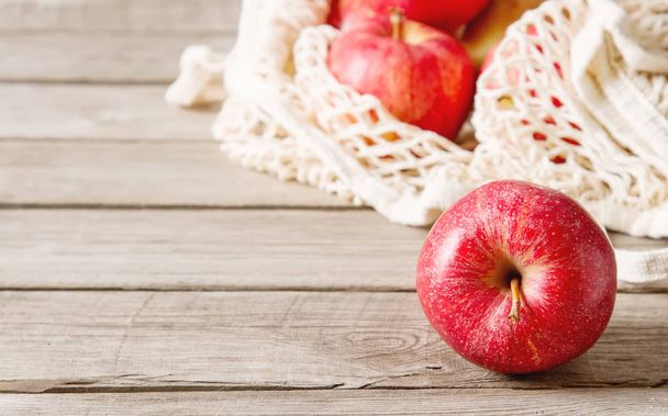 Ripe and juicy apples in a bag. Dark background. Copy space. Cle - 写真・画像