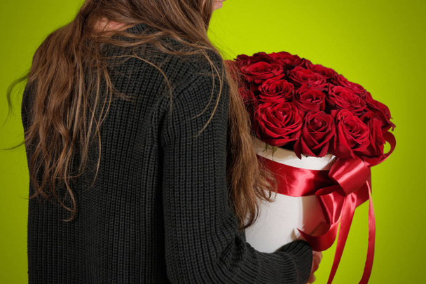 Girl in black jacket holding in hand rich gift bouquet of 21 red - Photo, image