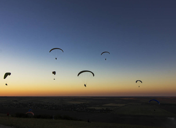 Paragliders in the evenyng sky with low light - Foto, Imagen