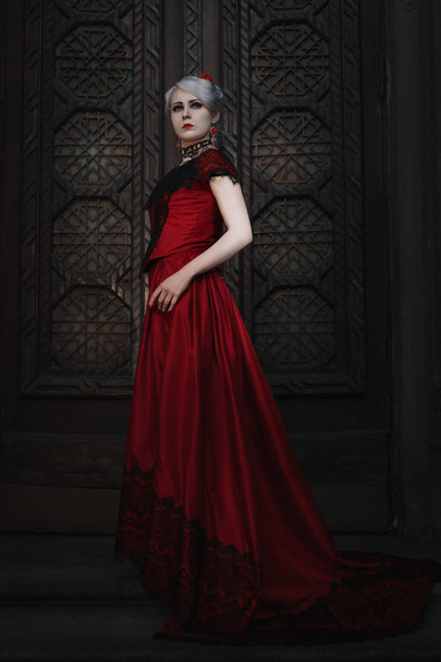 Woman in a red ball gown. - 写真・画像