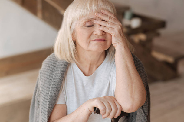 Sad elderly woman closing her eyes - Fotó, kép