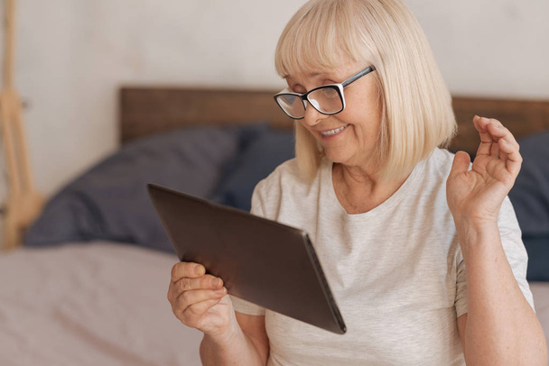 Cheerful positive woman looking at the tablet screen - Photo, Image