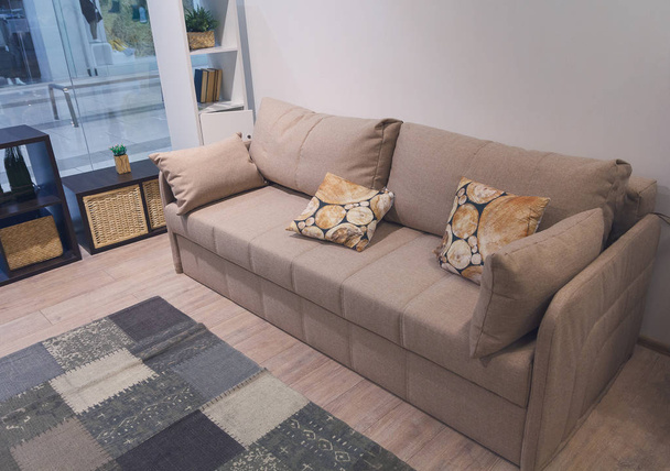 Стильний бежевий диван з великою кількістю подушок. Меблі
 - Фото, зображення