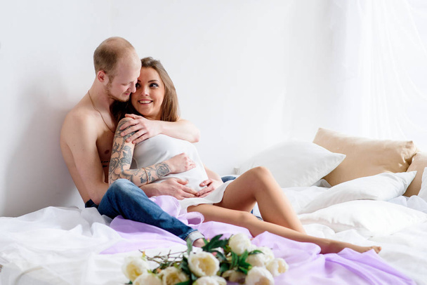 Beautiful couple in anticipation of a child, lie in bed. - Foto, Imagen