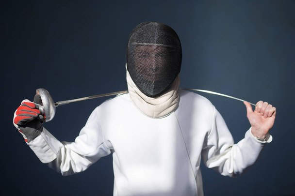 the fencer prepares for competitions. fencing coach. fencing sport motivation. mask and sword - Фото, изображение