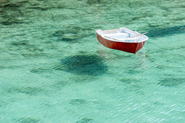Barca flutuando em água transparente em Maiorca
 - Foto, Imagem