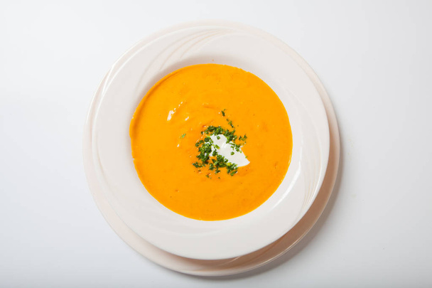Homemade pumpkin soup with cream with spices on white plate - Foto, Bild
