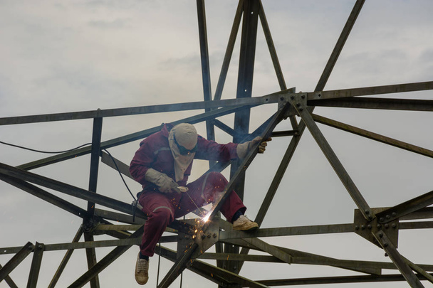 Работа сварщика на высоком электрическом столбе высокого напряжения 230 кВ
 - Фото, изображение
