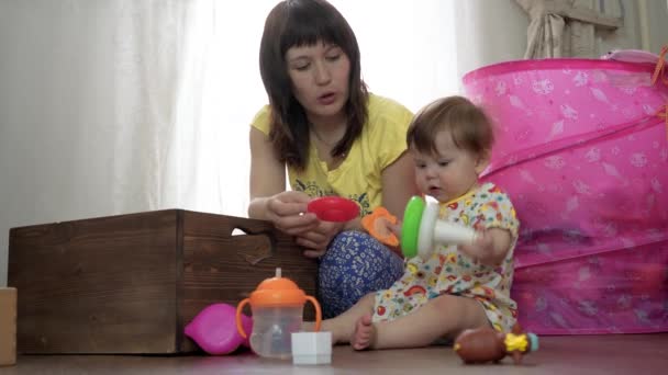 Mum plays with a small child in a room on the floor - Footage, Video