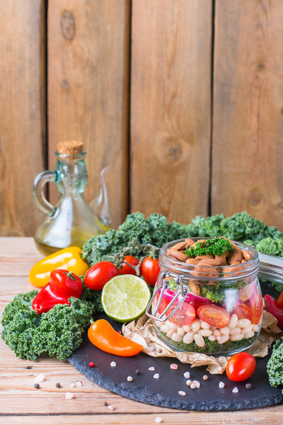 Salada vegan saudável em um frasco de pedreiro com feijão
 - Foto, Imagem