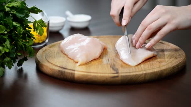 Handen van vrouw snijden van ruwe filets uit kip borsten close-up - Video