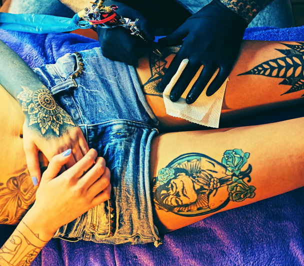 Making a tattoo on a woman's leg - Photo, Image