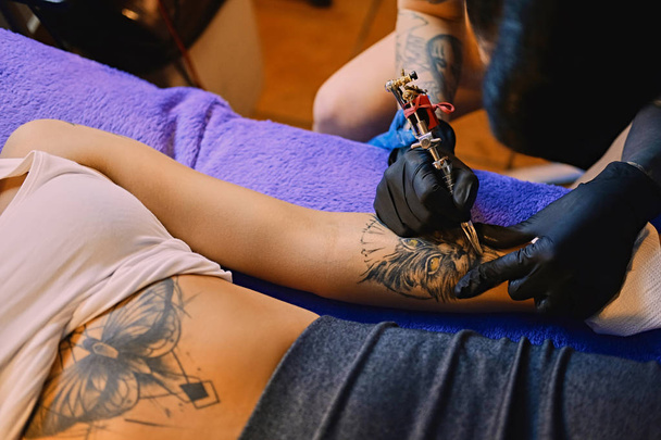 Making a tattoo on a woman's arm. - Photo, Image