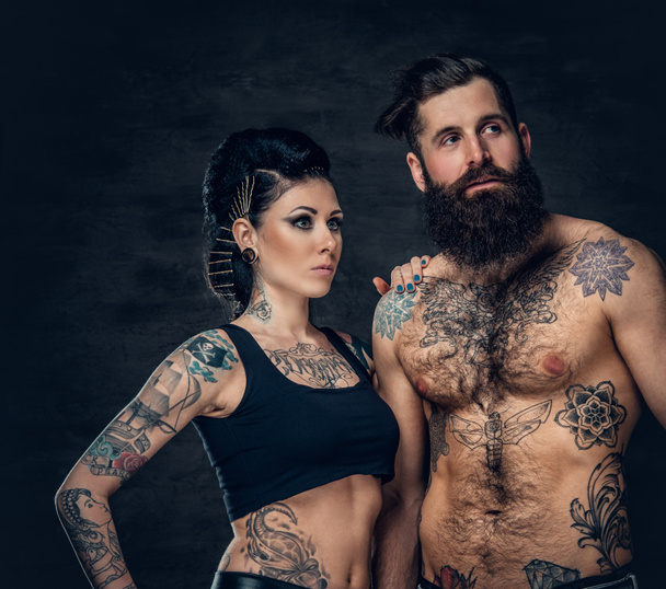 Hombre barbudo tatuado y mujer morena
 - Foto, Imagen