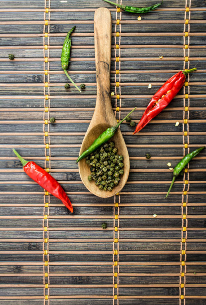 Chilli peppers spices and  wooden spoon on a rustic background. Top view - Photo, Image