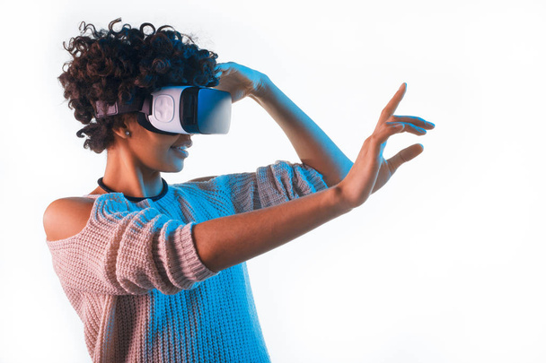 Pretty woman wearing VR goggles touching air - Фото, зображення