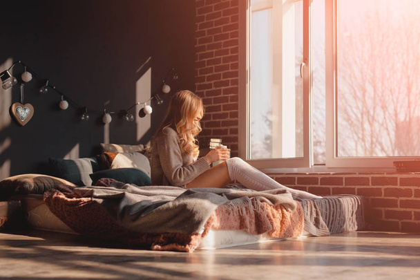 Woman sitting on bed in sun light - Photo, Image