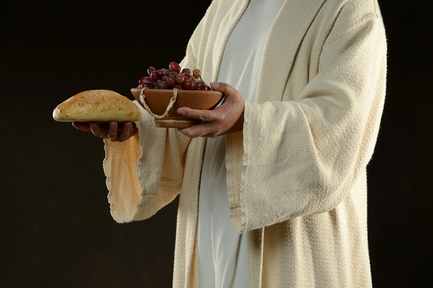 Jesus segurando um pão e uvas
 - Foto, Imagem