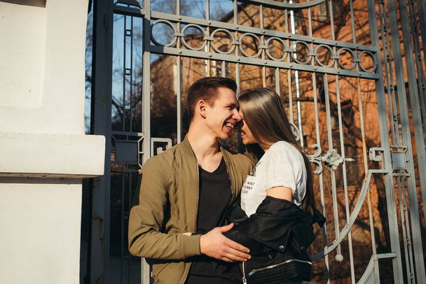 Young couple have fun in sunny day. Beautiful brunette girl and guy outdoor. The concept of tenderness and affection - Photo, Image