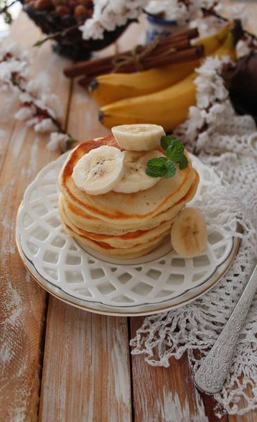 Τηγανίτες Μπανάνα για πρωινό σε ένα λευκό πιάτο. Ρουστίκ στυλ. - Φωτογραφία, εικόνα