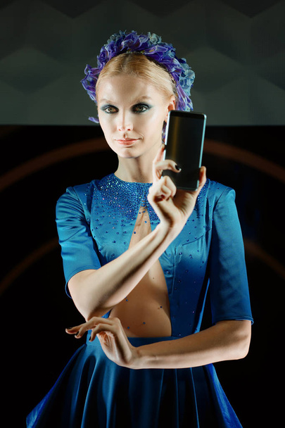 Beautiful fashion model holding smartphone in her hands. Present - Fotó, kép