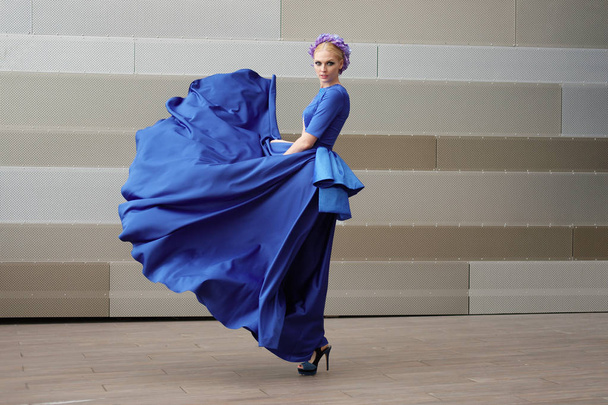 full length portrait of a fashion woman with her dress flying in the air  - Foto, imagen