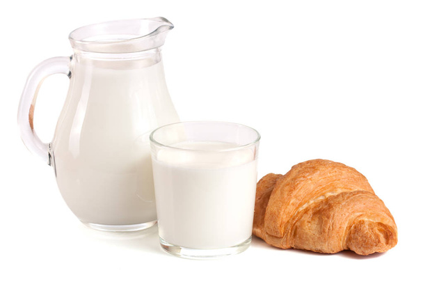 Jarra y vaso de leche con croissant aislado sobre fondo blanco
 - Foto, Imagen