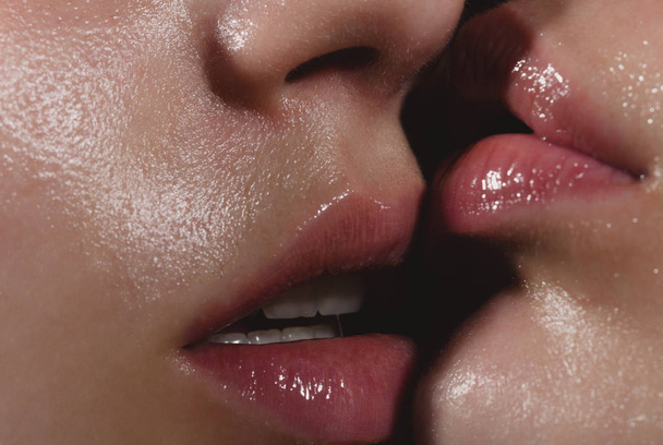 Wet faces and lips of two women, lesbians next. Women's lips with pink lip gloss. Sensual intimacy. Close relations - Photo, Image