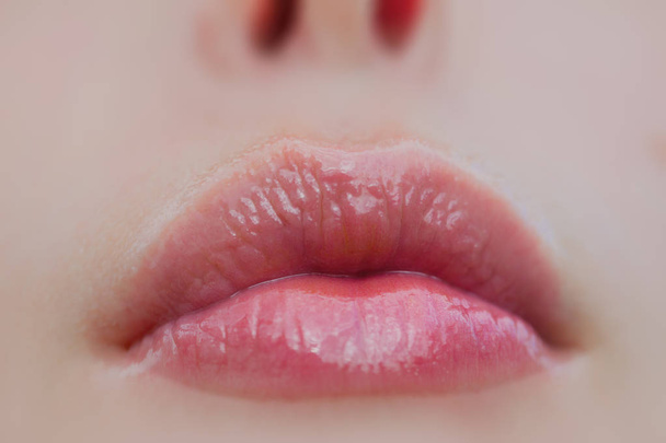 Healthy female lips without herpes. Sexy mouth of girl with lip balm. Part of woman's face. Mouth and nose of beautiful young lady. Natural lipstick with gloss. Cosmetics and cosmetology, make-up - Photo, Image