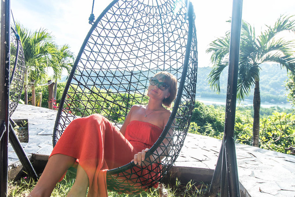 Concepto de vacaciones. Mujer joven columpio en isla tropical Nusa Lembongan, Bali, Indonesia
. - Foto, Imagen