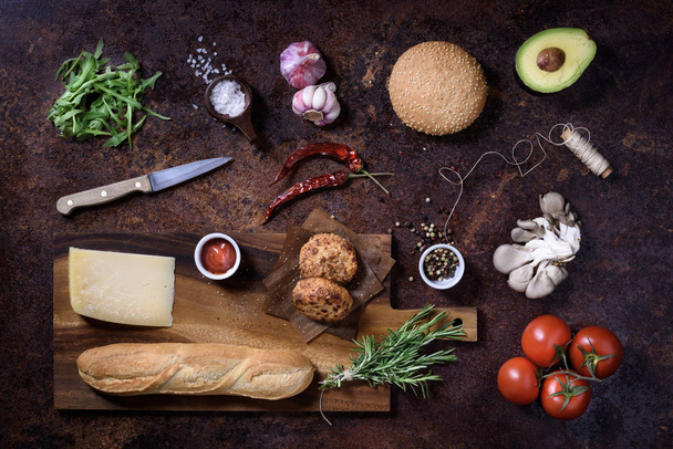 Fresh homemade sandwich on dark serving board with vegetables, cheese, salt and herbs over dark background. Top view, copy space.  - Φωτογραφία, εικόνα