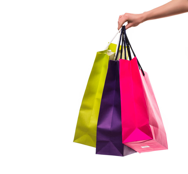Mulher mão com sacos de compras no fundo branco
 - Foto, Imagem