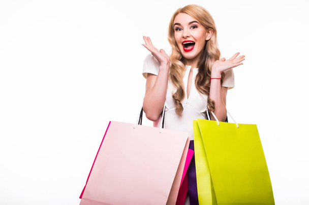 Attractive young woman with shopping bags on white - 写真・画像
