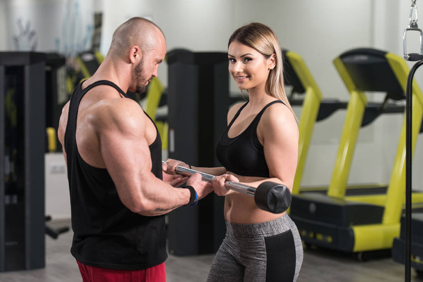 Woman Exercising Biceps With Her Personal Trainer - Photo, Image