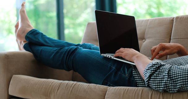 Man using laptop in living room - Zdjęcie, obraz