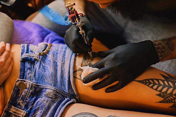 Tattoo kunstenaar maakt een tatoeage - Foto, afbeelding