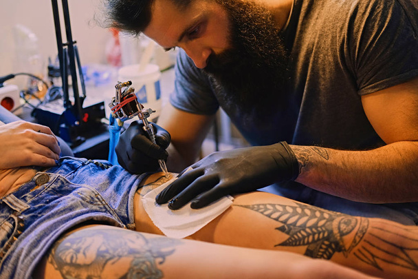 Tatuaje artista hace un tatuaje
 - Foto, imagen
