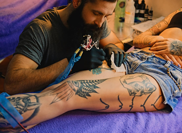 Татуировщик делает татуировку
 - Фото, изображение