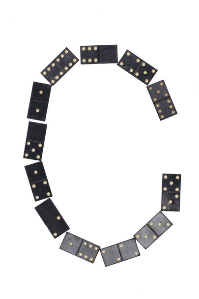 letter C gemaakt van zwarte dominostenen tegels - Foto, afbeelding