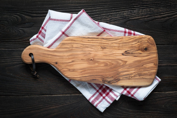 Cutting board on dark wooden table. - Fotografie, Obrázek