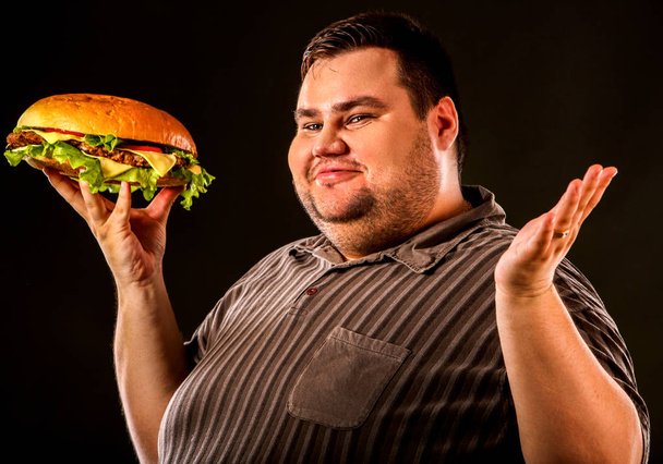 Homem gordo a comer hambúrguer de fast food. Pequeno-almoço para pessoa com excesso de peso
. - Foto, Imagem
