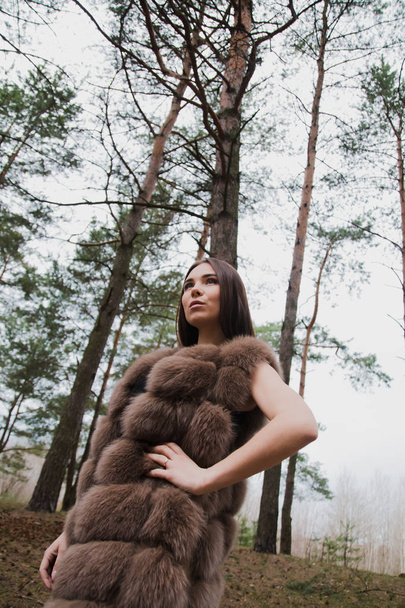 Portrait of a very beautiful girl in a forest dressed in fur - Φωτογραφία, εικόνα