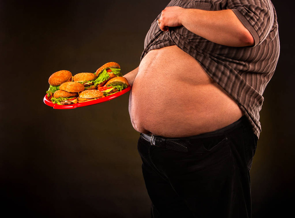 Man belly fat with hamberger fast food for overweight person. - Foto, imagen