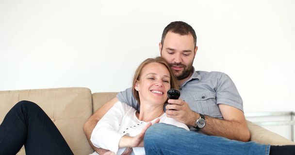 casal sênior assistindo tv na villa moderna
 - Foto, Imagem