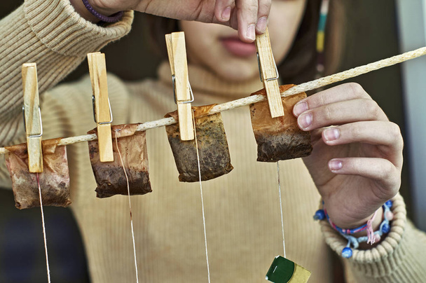 Girl hanging used tea bags for second use - Photo, Image