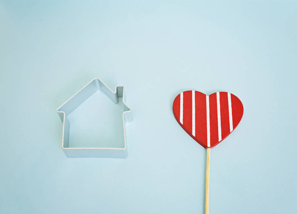 Kleines Haus und rotes Herz auf blauem Hintergrund - Foto, Bild
