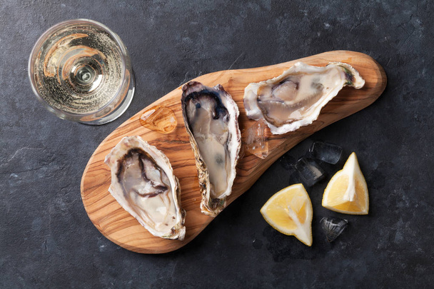 huîtres sur planche à découper et vin blanc
 - Photo, image