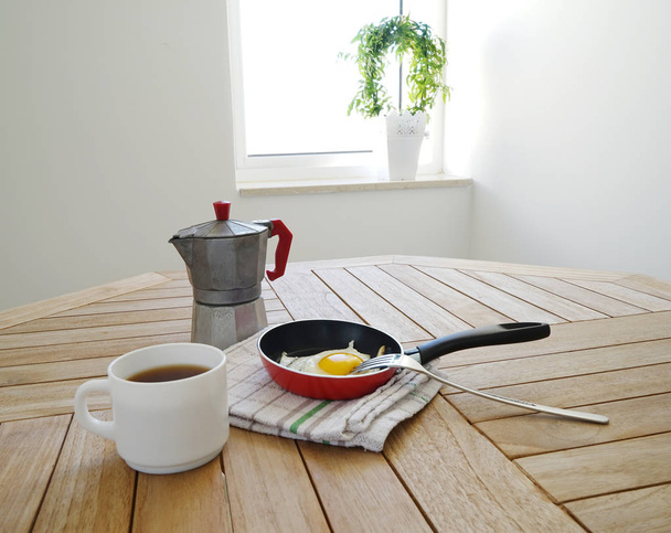 Жареные яйца с кофейником на столе
 - Фото, изображение
