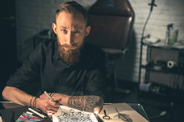 Wistful male with tattoo painting image - 写真・画像